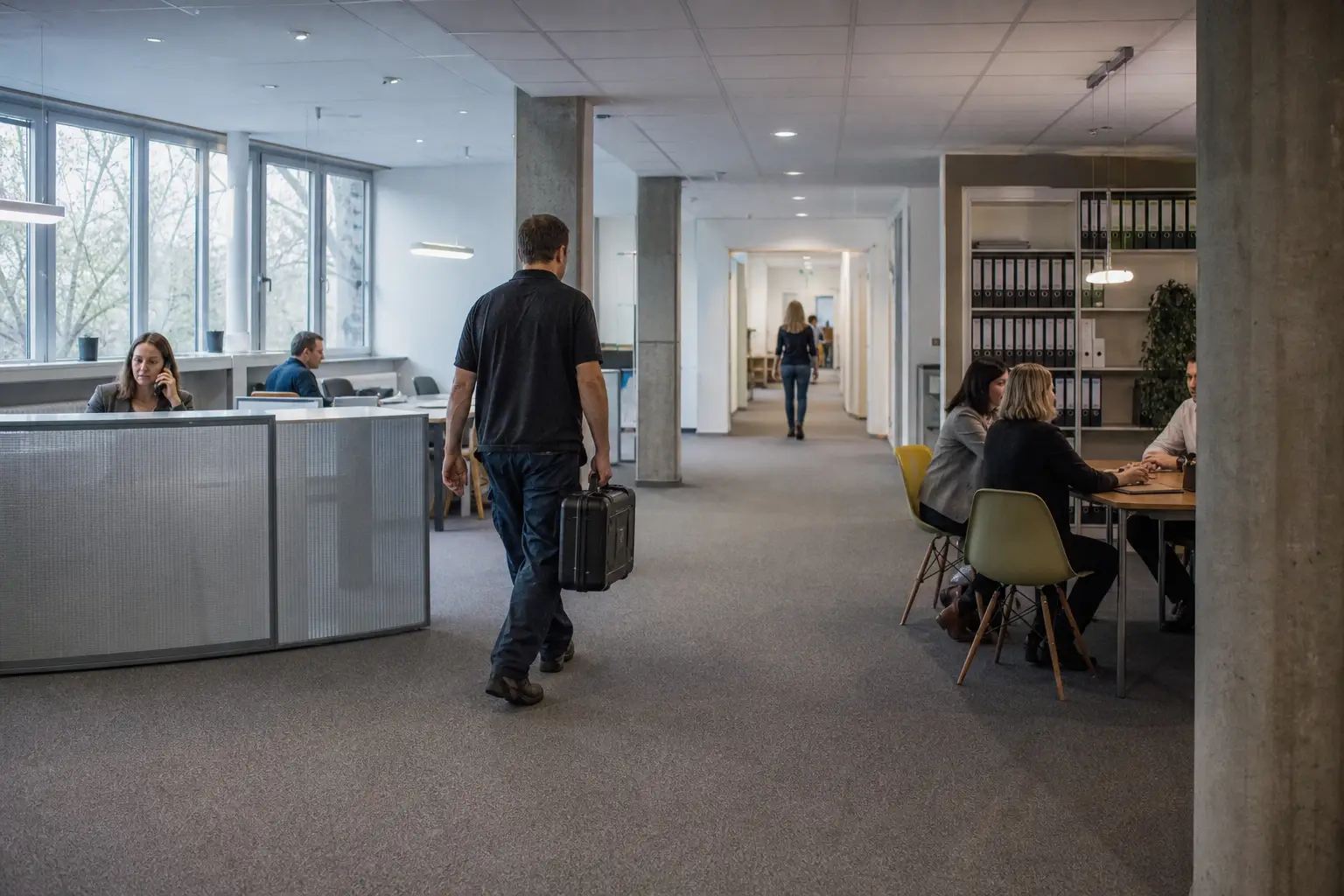 Techniker unterwegs zwischen Verwaltung, Empfang und Arbeitsbereichen.