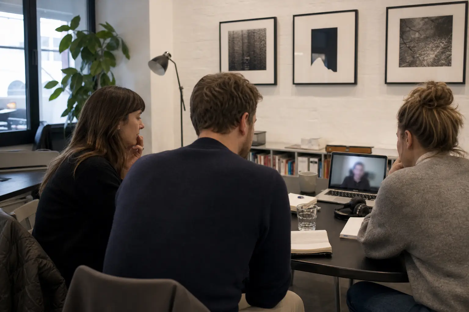 Kleines Team arbeitet gemeinsam im Büro und per Videokonferenz.
